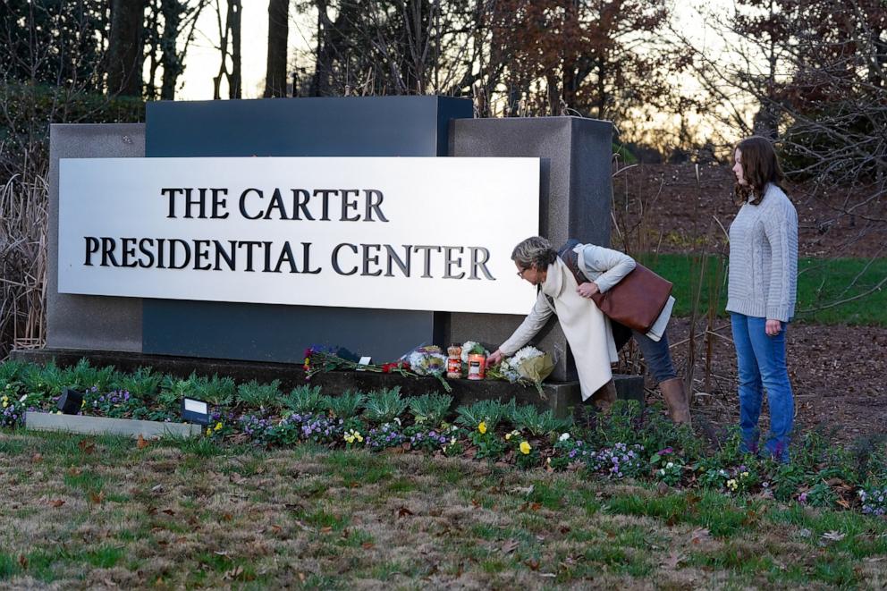 PHOTO: Amy Cornell and Nolan Cornell-Cook leave a momento at a makeshift memorial at The Carter Presidential Center following the death of Jimmy Carter on Dec. 29, 2024 in Atlanta.