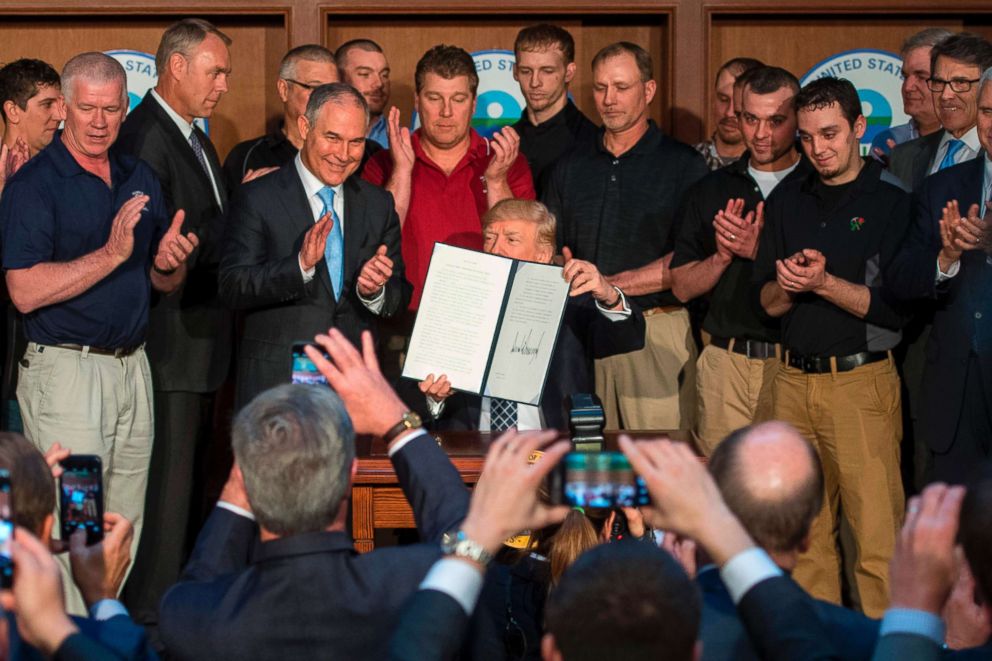 PHOTO: Surrounded by miners from Rosebud Mining, President Donald Trump shows the signed Energy Independence Executive Order at the Environmental Protection Agency Headquarters in Washington, DC, March 28, 2017.
