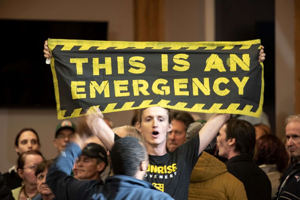 PHOTO: A climate change protester holds a banner reading "This Is An Emergency," during a town hall event with former Vice President Joe Biden, 2020 Democratic presidential candidate, in Manchester, New Hampshire, Oct. 9, 2019.