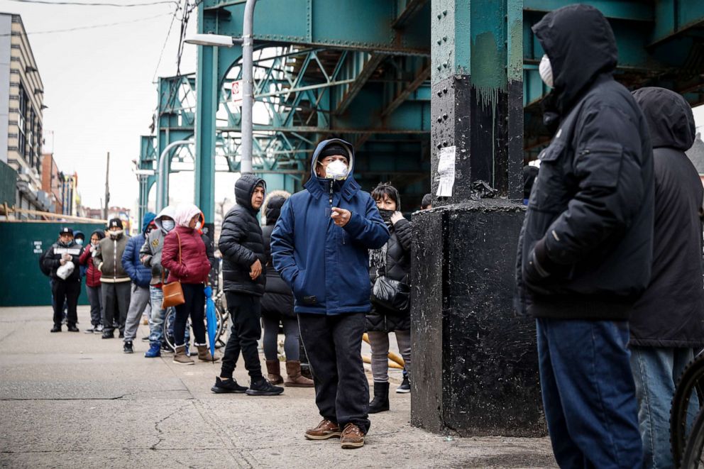 PHOTO: Patients wait in line outside an urgent care pharmacy while wearing personal protective equipment, March 25, 2020, in Queens, New York.