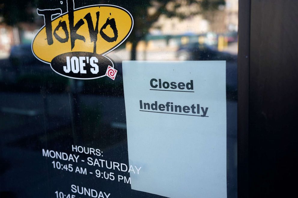 PHOTO: A sign hangs on the door of a restaurant indicating that the eatery will remain closed, May 28, 2021, in Denver.