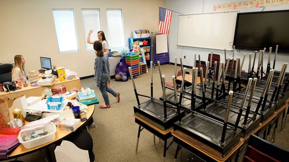 PHOTO: Teachers confer with each other in an empty classroom at Freedom Preparatory Academy on May 18, 2020, in Provo, Utah.