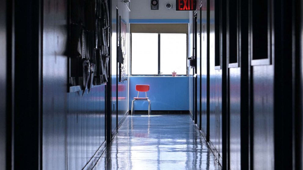 PHOTO: A chair remains by a window in an empty hallway in the closed Yung Wing School P.S. 124 on May 14, 2020, in New York.