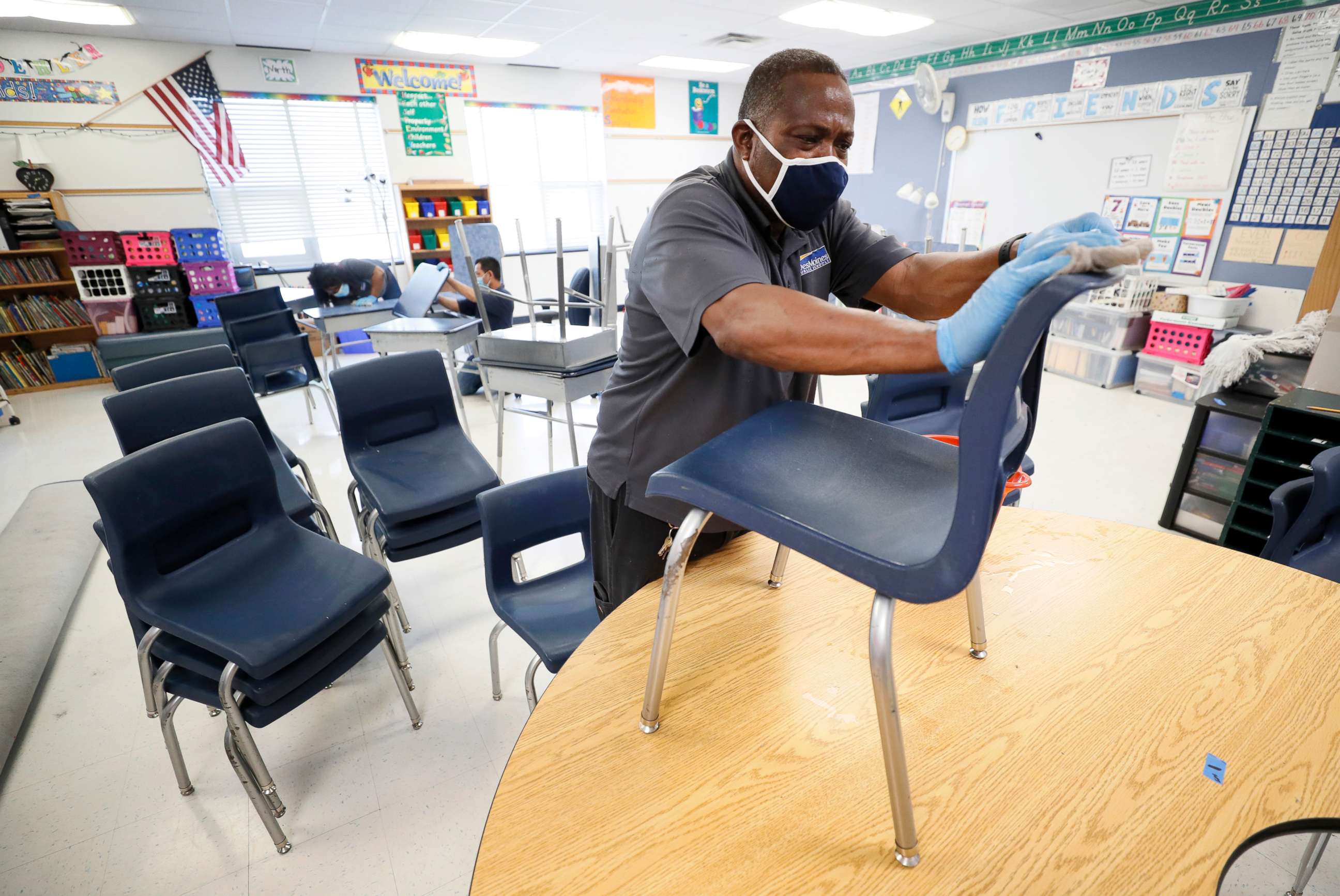 PHOTO: Des Moines Public Schools custodian Tracy Harris cleans chairs in a classroom at Brubaker Elementary School, July 8, 2020, in Des Moines, Iowa.