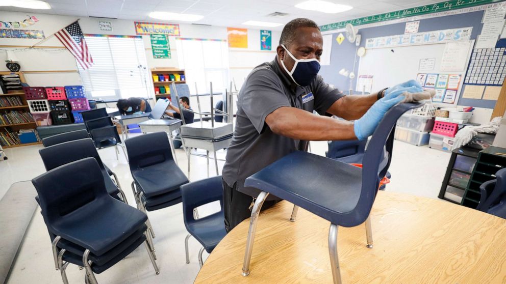 PHOTO: Des Moines Public Schools custodian Tracy Harris cleans chairs in a classroom at Brubaker Elementary School, July 8, 2020, in Des Moines, Iowa.
