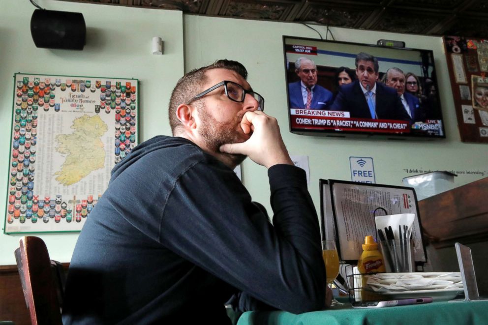 PHOTO: A patron at Duffy's Irish Pub watches the testimony of Michael Cohen before a House Committee on Oversight and Reform, in Washington, DC, Feb. 27, 2019.