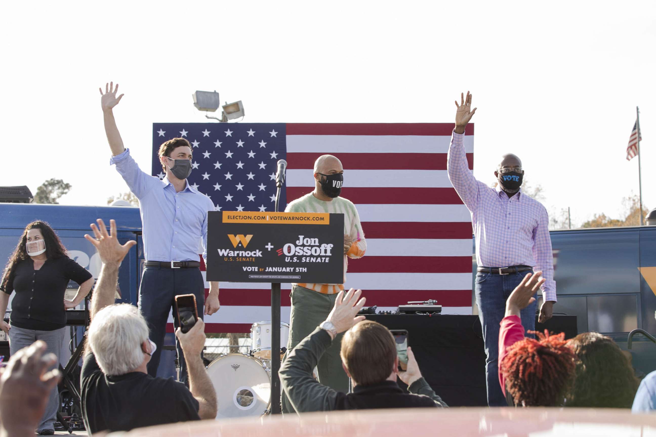 PHOTO: Jon Ossoff, Common, and Raphael Warnock wave to attendees during a 'It's Time To Vote' rally at Garden City Stadium in Garden City, Ga., Dec. 19, 2020.