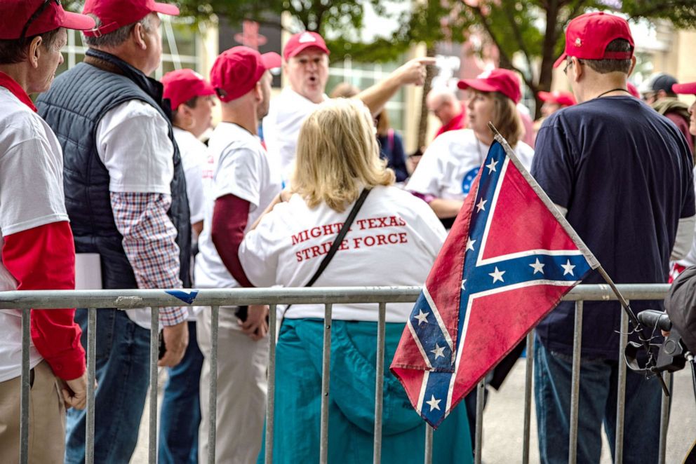 PHOTO: An attendee displays a confederate flag while waiting in line outside the Toyota Center ahead of a rally with President Donald Trump and Senator Ted Cruz in Houston, Oct. 22, 2018. 