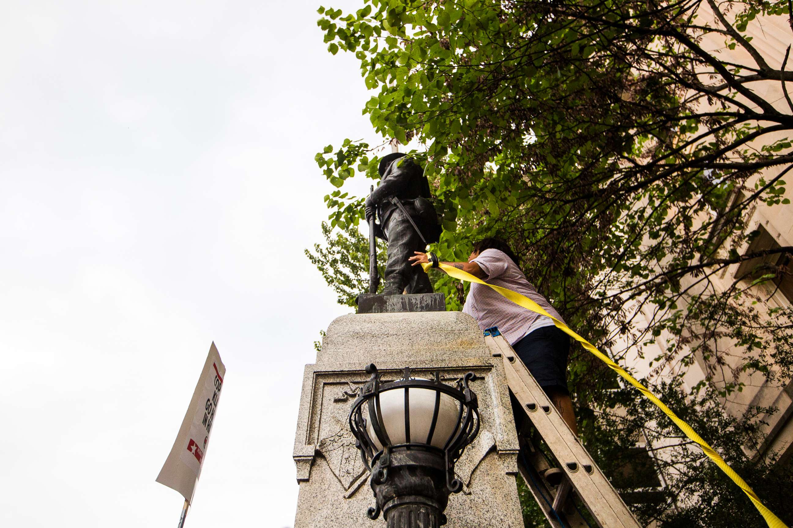 PHOTO: An unidentified protester climbs a ladder to place a rope around a Confederate statue during a rally Monday, Aug. 14, 2017, in Durham, N.C.
