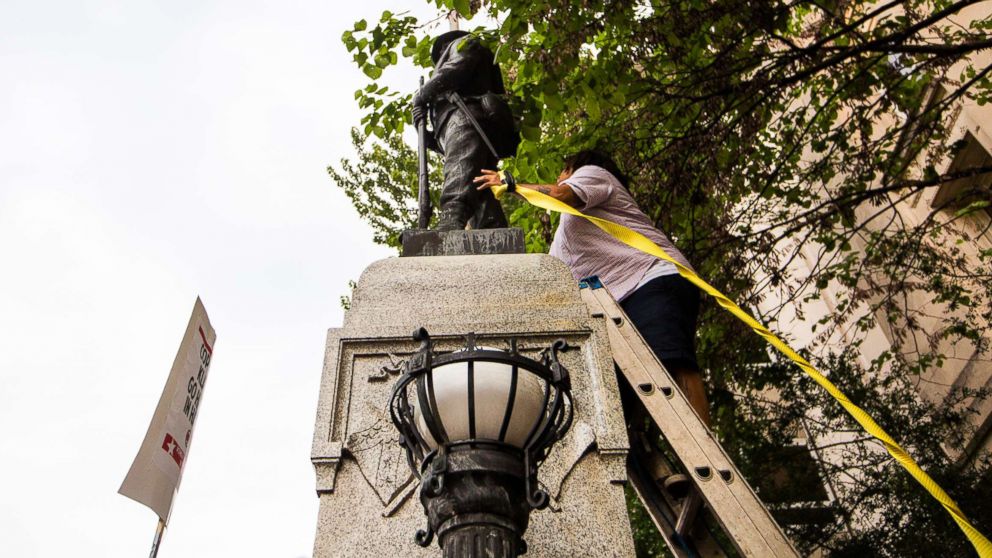 PHOTO: An unidentified protester climbs a ladder to place a rope around a Confederate statue during a rally Monday, Aug. 14, 2017, in Durham, N.C.