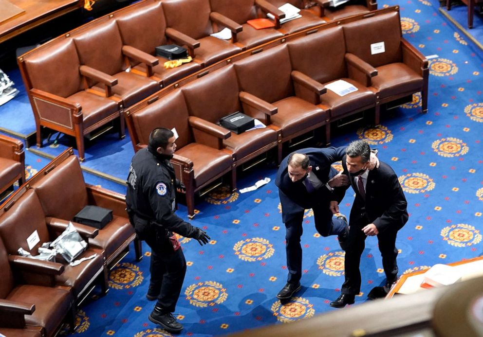 PHOTO: Members of congress run for cover as protesters try to enter the House Chamber during a joint session of Congress, Jan. 6, 2021 in Washington, D.C.