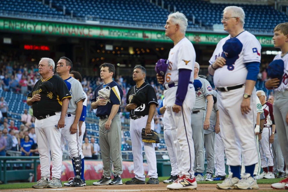 PHOTO: Members of the Democratic and Republican baseball teams stand for the national anthem to start the 57th Congressional Baseball Game at National's Park in Washington, June 14, 2018.