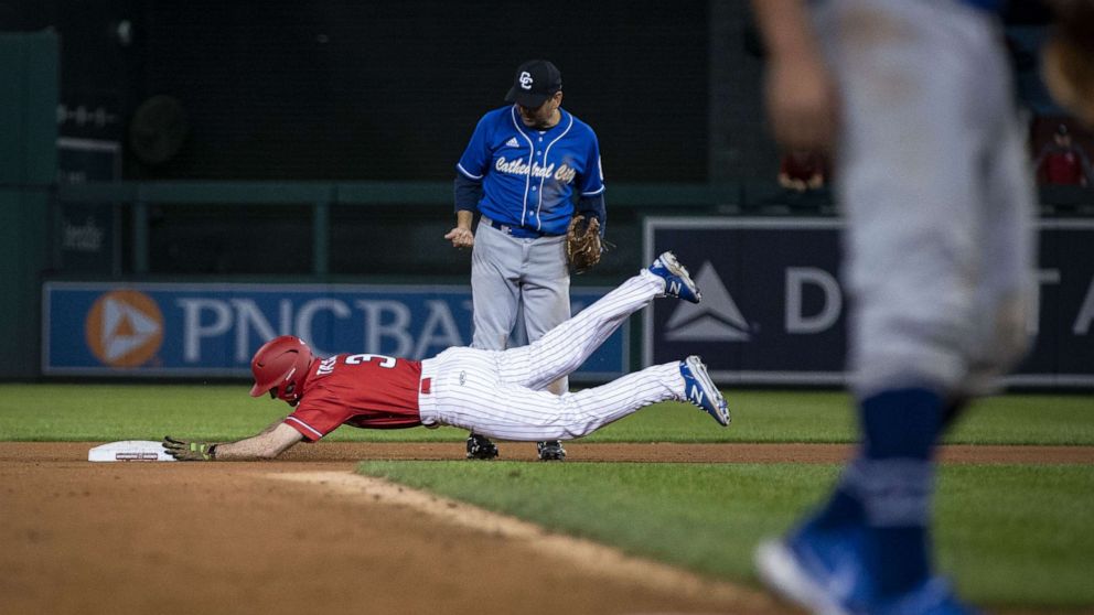 PHOTO: Rep. Nicholas Van Taylor, a Republican from Texas, slides into second base as Rep. Raul Ruiz, a Democrat from California, looks on during the Congressional Baseball Game at Nationals Park in Washington, Sept. 29, 2021.