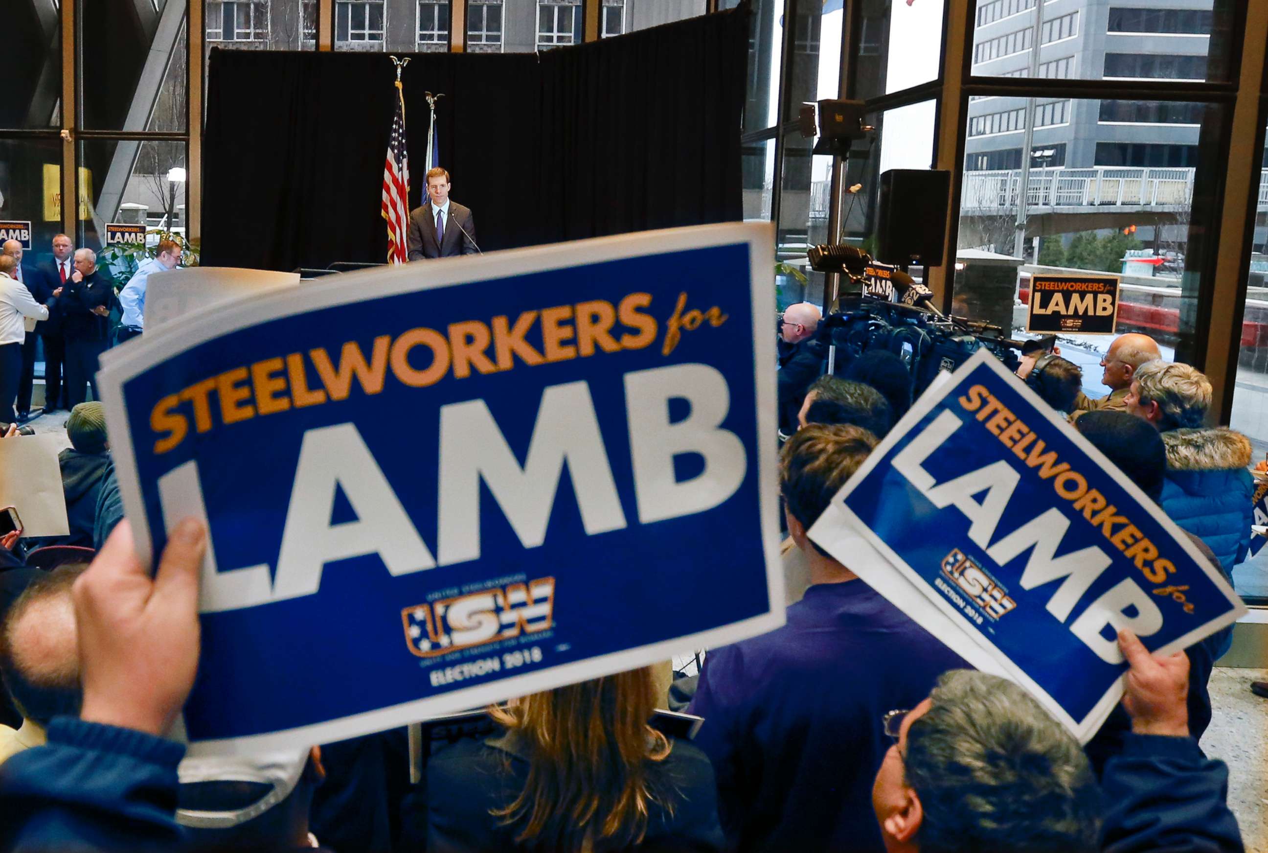 PHOTO: Democrat Conor Lamb, top, addresses the crowd as they hold signs of support during a campaign rally at the United Steelworkers headquarters in Pittsburgh, March 9, 2018.