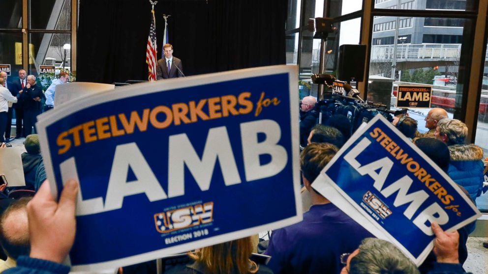 PHOTO: Democrat Conor Lamb, top, addresses the crowd as they hold signs of support during a campaign rally at the United Steelworkers headquarters in Pittsburgh, March 9, 2018.