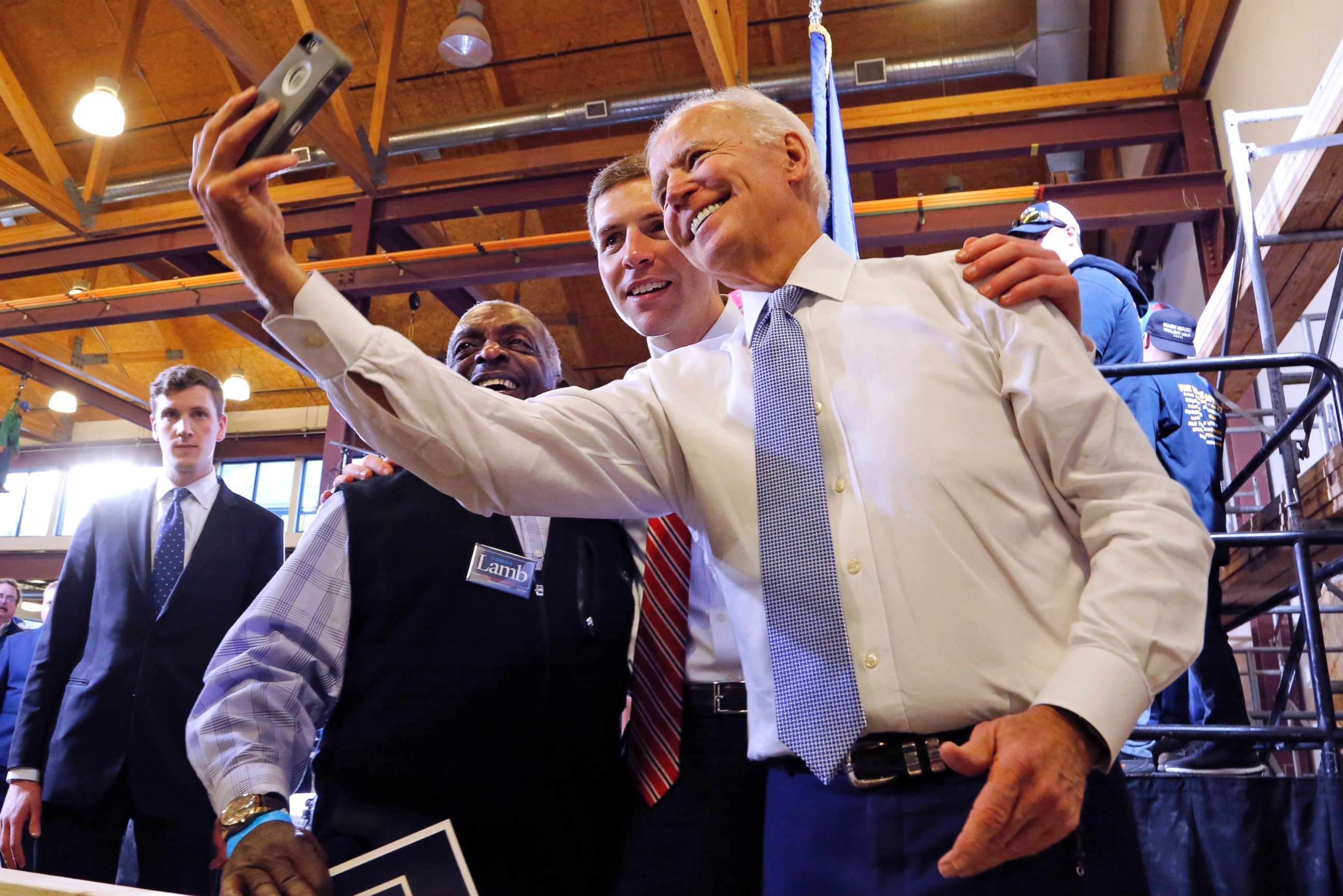 PHOTO: Conor Lamb, center, the Democratic candidate for the March 13 special election in Pennsylvania's 18th Congressional District, and former Vice President Joe Biden pose for a selfie with a supporter during a rally in Collier, Pa., March 6, 2018.