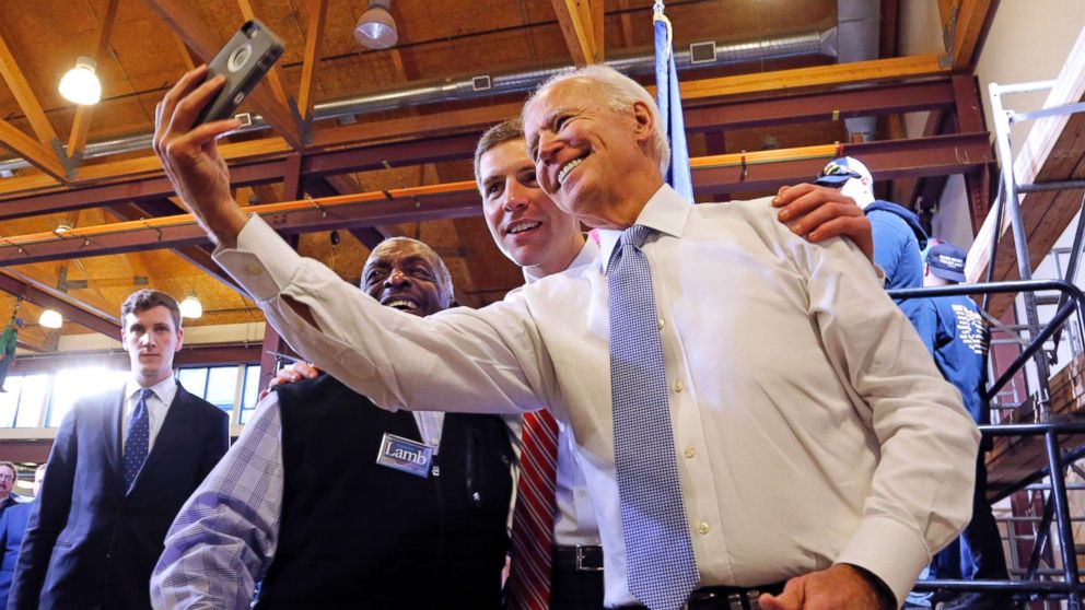 Conor Lamb, center, the Democratic candidate for the March 13 special election in Pennsylvania's 18th Congressional District, and former Vice President Joe Biden pose for a selfie with a supporter during a rally in Collier, Pa., March 6, 2018.