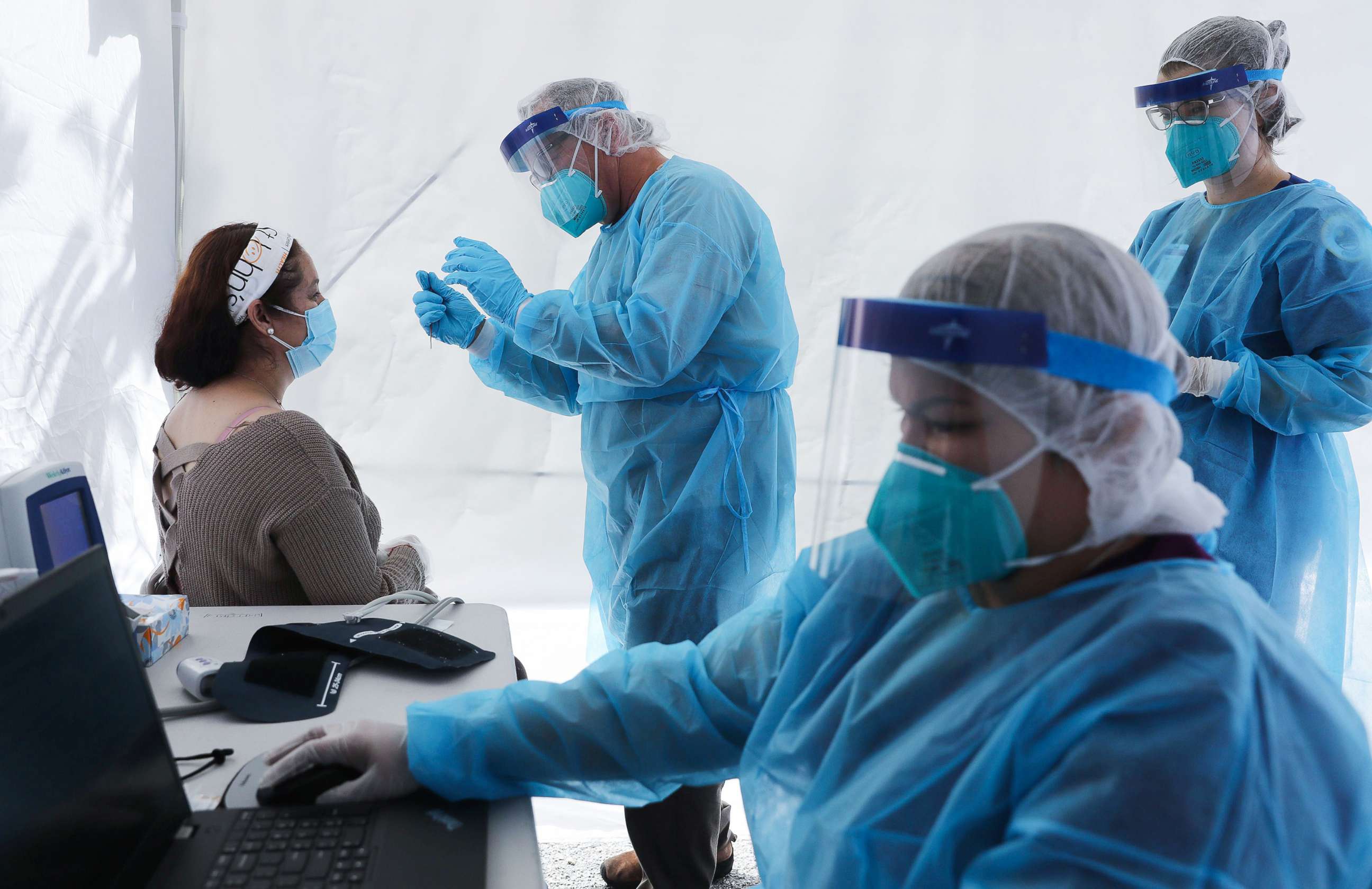 PHOTO: St. Johns Well Child &amp; Family Center workers prepare to test a woman for COVID-19 at a free mobile test clinic set up outside Walker Temple AME Church in South Los Angeles amid the coronavirus pandemic on July 15, 2020 in Los Angeles.