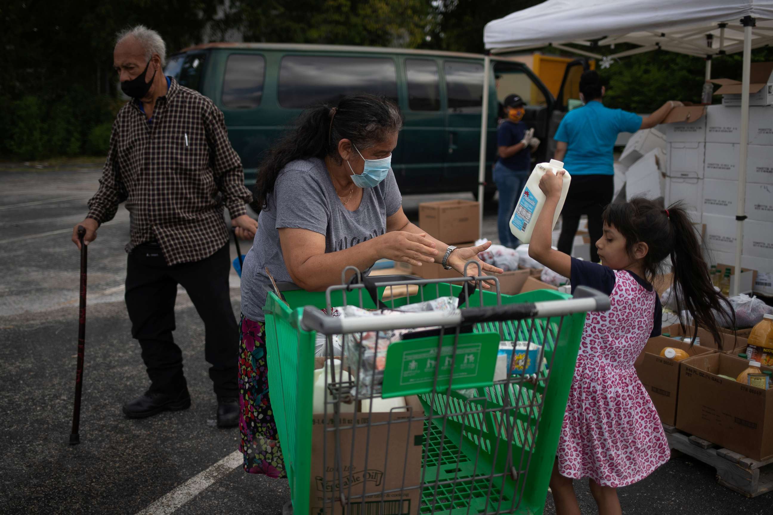 PHOTO: Amber, 5, helps her grandmother Minerva Delgado load groceries distributed by the Wesley Community Center to residents affected by the economic fallout caused by the coronavirus disease (COVID-19) outbreak in Houston, July 24, 2020.