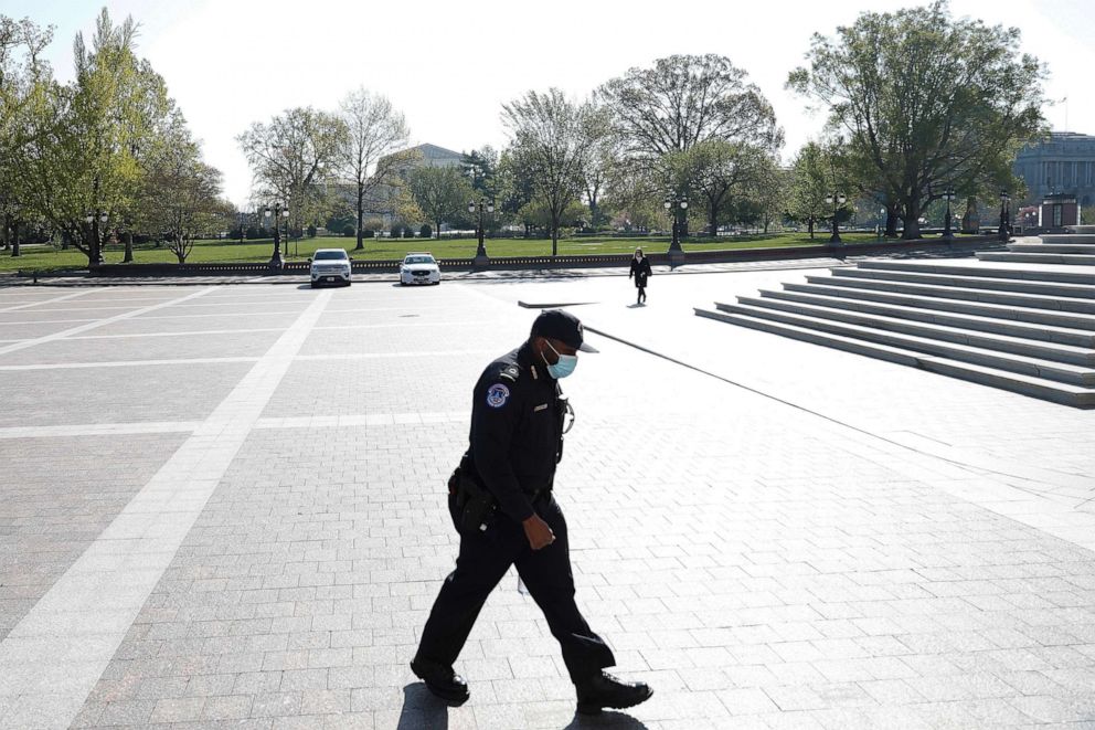 PHOTO: A U.S. Capitol Police Officer walks across the East Front wearing a face mask on Capitol Hill, April 9, 2020.