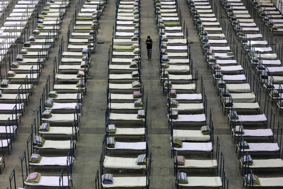 PHOTO: A worker walks between rows of beds in a convention center, converted into a temporary hospital, in Wuhan in central China's Hubei Province, Feb. 4, 2020. President Xi Jinping said "we have launched a people's war of prevention of the epidemic."