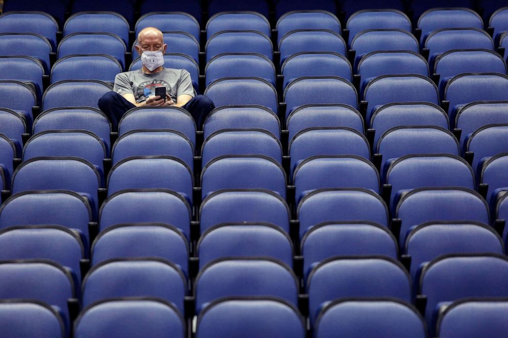 PHOTO: Mike Lemcke, from Richmond, Va., sits in an empty Greensboro Coliseum after the NCAA college basketball games were cancelled at the Atlantic Coast Conference tournament in Greensboro, N.C., March 12, 2020. 