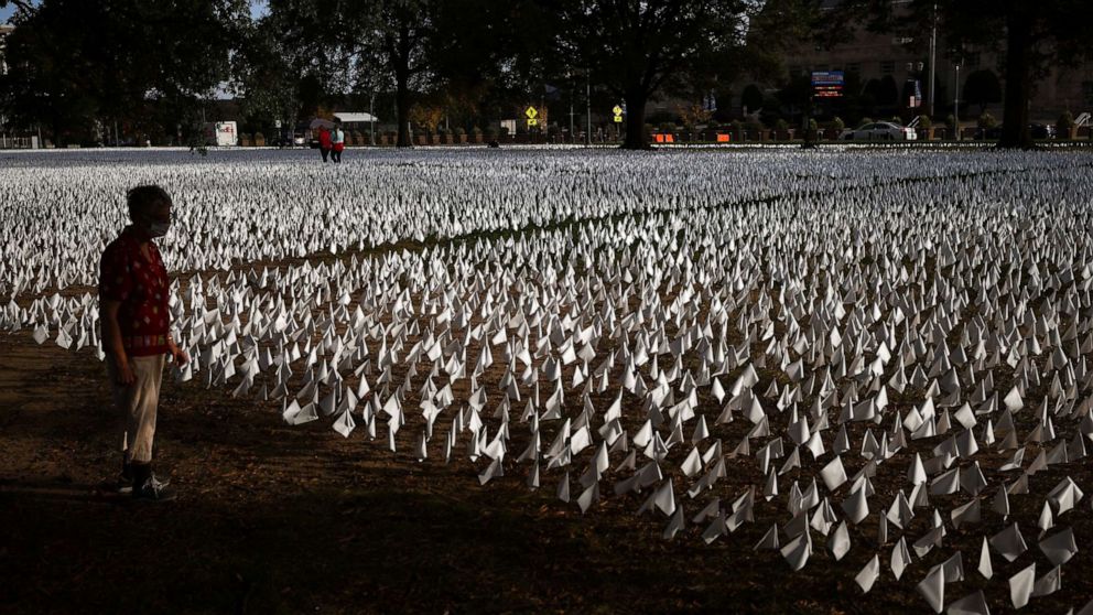 PHOTO: A person looks at a field of an estimated 240,000 white flags planted to represent U.S. deaths due to COVID-19, at the D.C. Armory Parade Ground in Washington, D.C., Oct. 23, 2020.