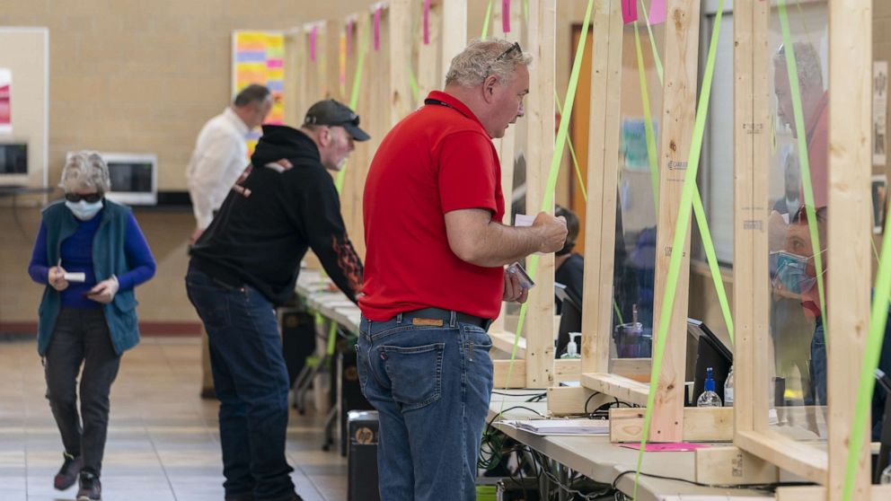PHOTO: People check in to vote at a polling place on April 7, 2020, in Sun Prairie, Wis.