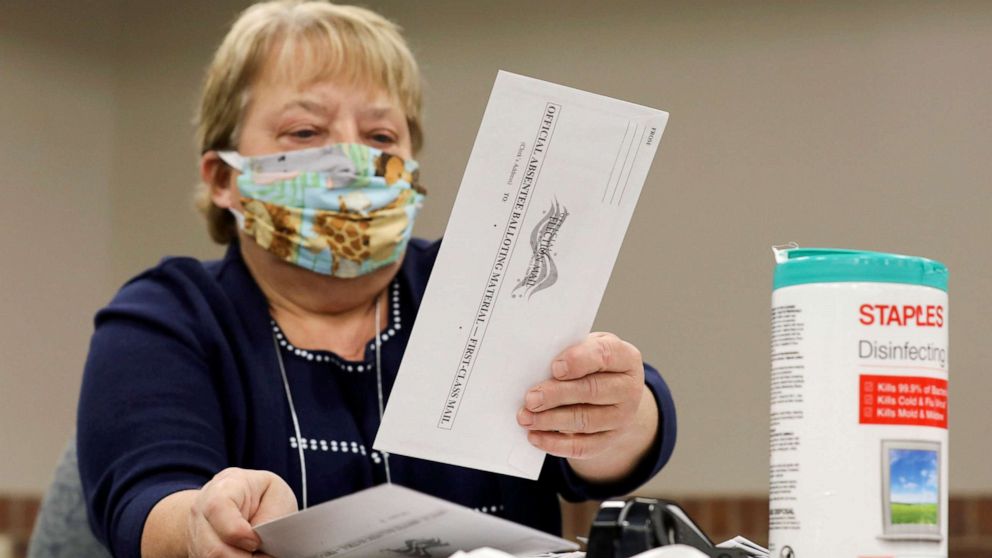 PHOTO: Election volunteer Nancy Gavney verifies voter and witness signatures on absentee ballots as they are counted at the City Hall during the presidential primary election held amid the coronavirus disease outbreak in Beloit, Wis., April 7, 2020.