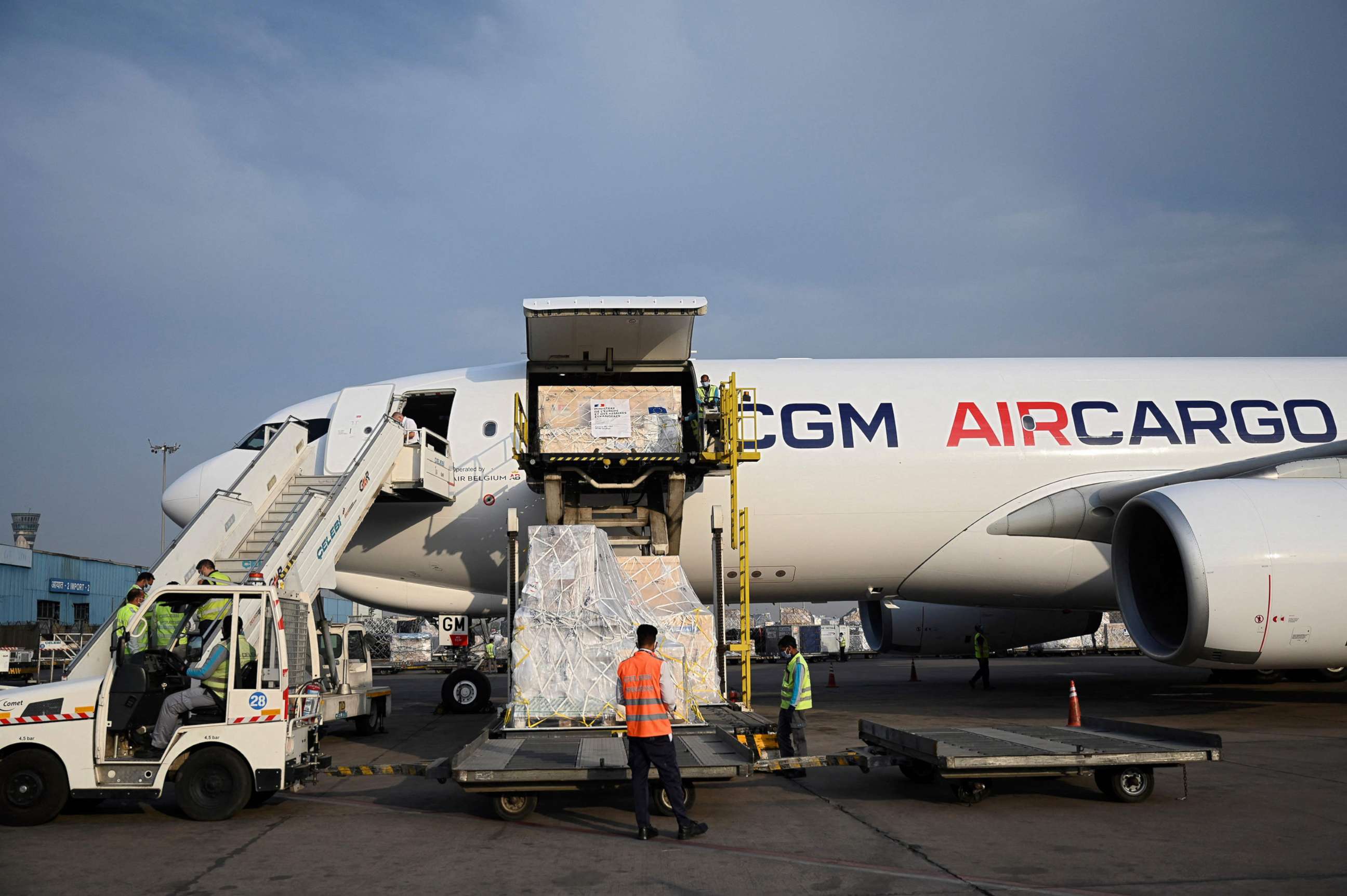 PHOTO: Ground staff unload the COVID-19 coronavirus medical supplies from France, upon the arrival of a cargo plane at the Indira Gandhi International Airport in New Delhi on May 2, 2021.