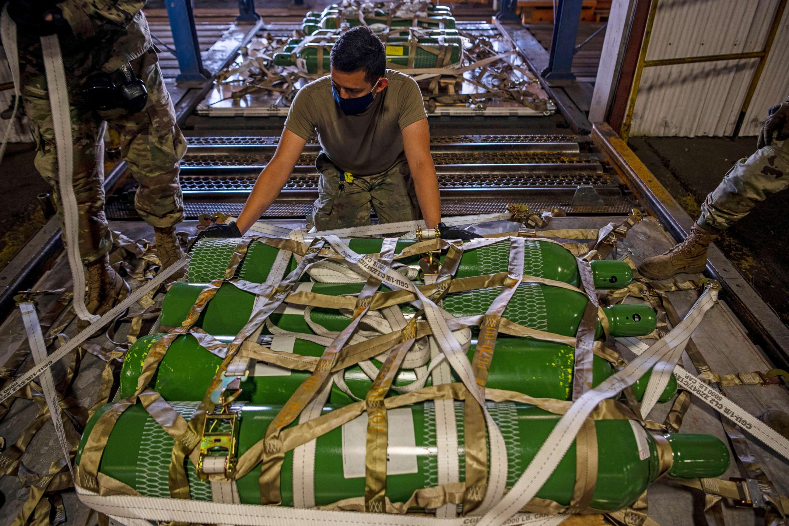 PHOTO: Airman 1st Class Fernando Beltran secures oxygen cylinders to a pallet on April 28, 2021, at Travis Air Force Base, Calif.