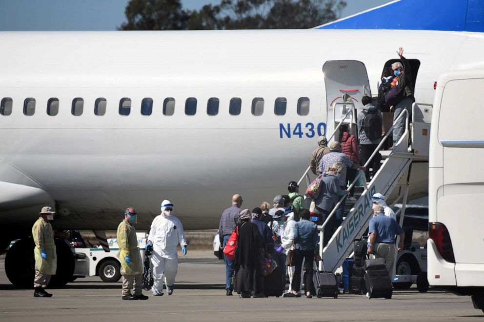 PHOTO: Passengers from the cruise ship Grand Princess board a chartered flight at Oakland International Airport in Oakland, Calif. March 11, 2020.