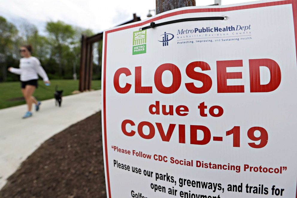 PHOTO: A woman walks a dog through a park where the access to playground equipment has been closed off because of the coronavirus, April 3, 2020, in Nashville, Tenn.