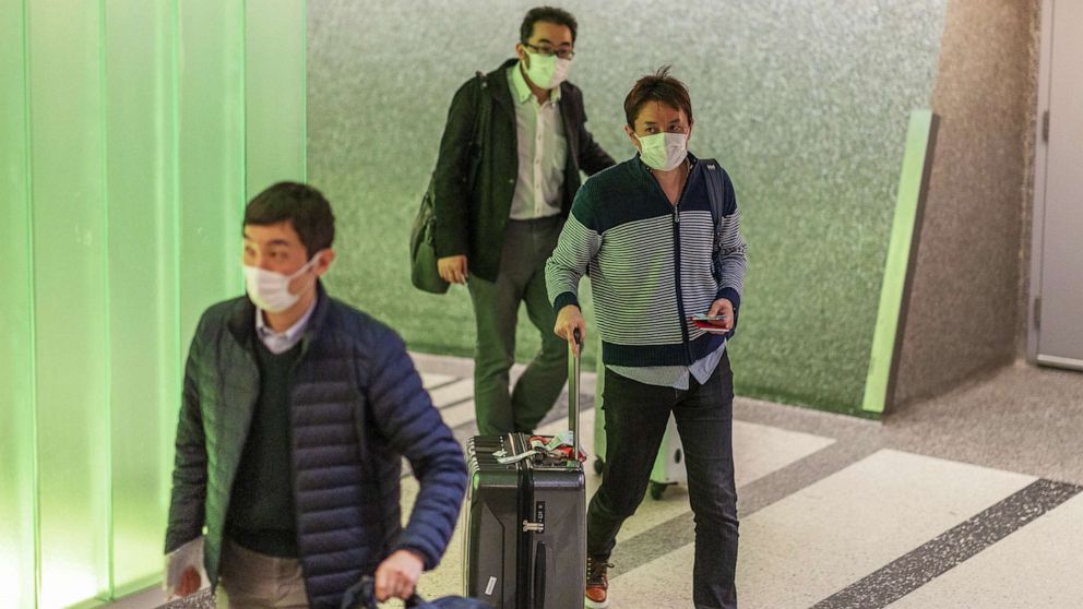 PHOTO: Travelers arrive to LAX Tom Bradley International Terminal wearing medical masks for protection against the novel coronavirus outbreak, Feb. 2, 2020 in Los Angeles.