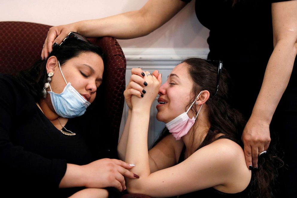 PHOTO: Jessica Holguin, 25, comforts her younger sister Natalie Holguin at the viewing service of their father Jose Holguin, who died of complications related to the coronavirus disease, in the Harlem neighborhood of New York, May 16, 2020.