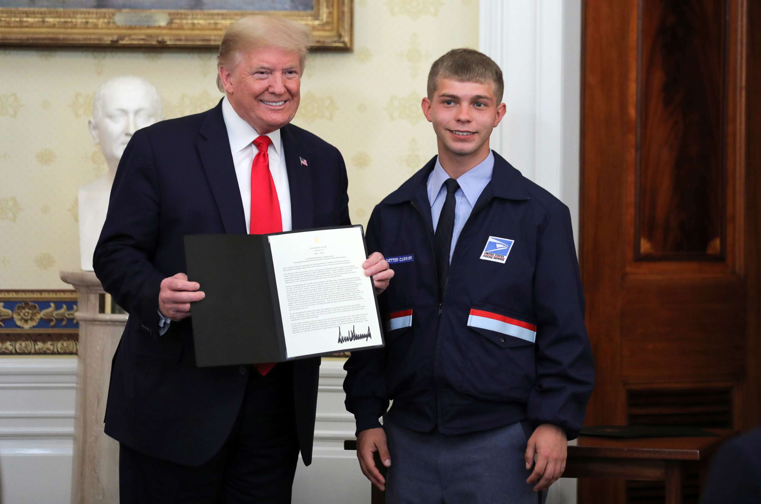 PHOTO: President Donald Trump presents a "Presidential Message of Appreciation" to Kyle West of Cincinnati for his actions delivering essential supplies requested by the elderly people living along his mail route, at the White House, May 1, 2020.