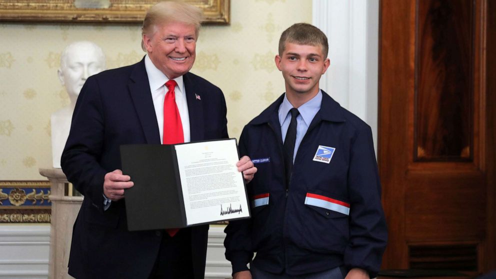 PHOTO: President Donald Trump presents a "Presidential Message of Appreciation" to Kyle West of Cincinnati for his actions delivering essential supplies requested by the elderly people living along his mail route, at the White House, May 1, 2020.