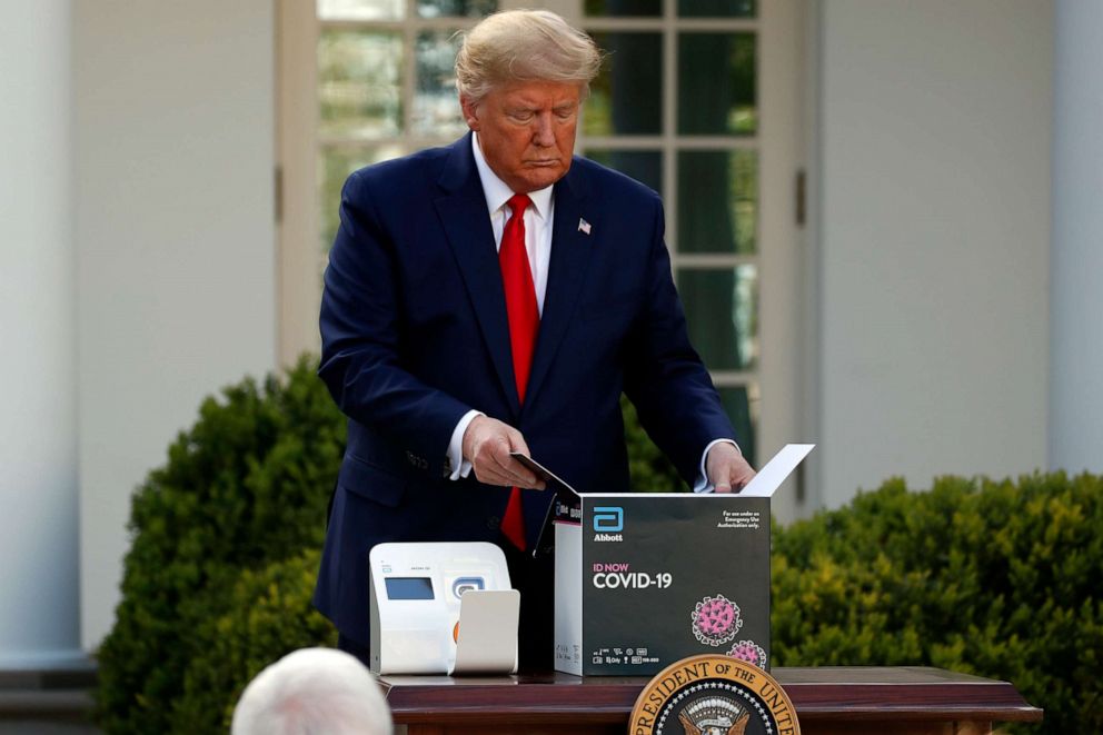 PHOTO: President Donald Trump opens a box containing a 5-minute test for COVID-19 from Abbott Laboratories as Health and Human Services Secretary Alex Azar speaks about the coronavirus in the Rose Garden of the White House, March 30, 2020, in Washington.