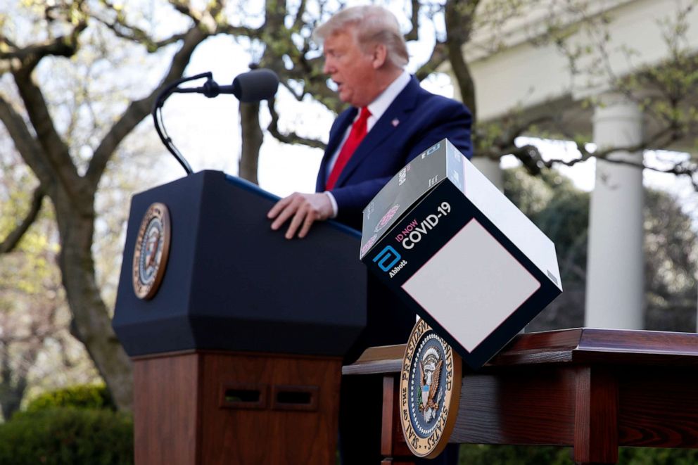 PHOTO: President Donald Trump speaks as a box containing a 5-minute test for COVID-19 from Abbott Laboratories blows off a table about the coronavirus in the Rose Garden of the White House, March 30, 2020, in Washington.
