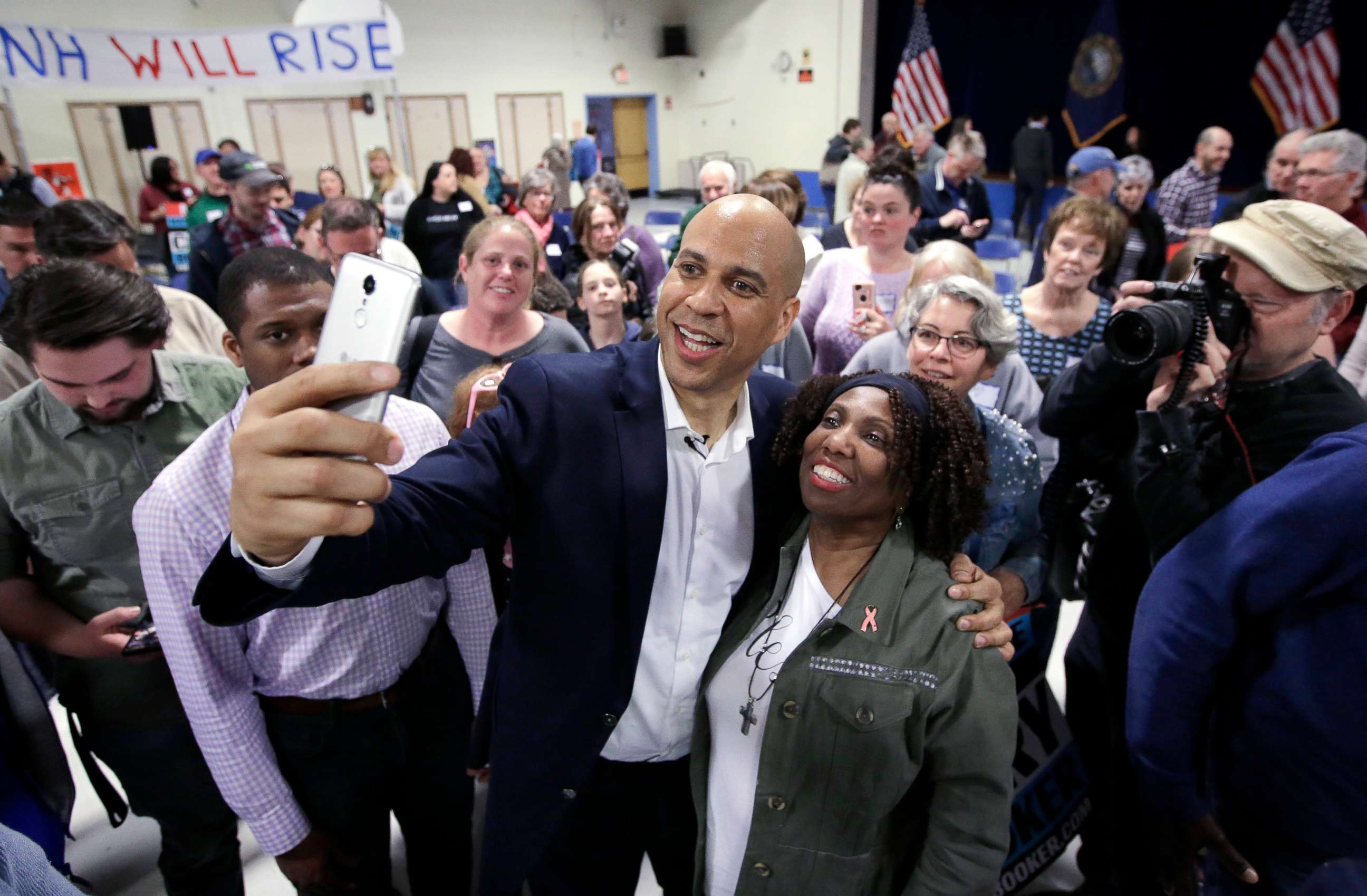 PHOTO: Sen. Cory Booker takes selfies with residents at the conclusion of a 2020 presidential campaign stop, April 7, 2019, in Londonderry, N.H.