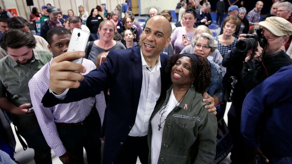 PHOTO: Sen. Cory Booker takes selfies with residents at the conclusion of a 2020 presidential campaign stop, April 7, 2019, in Londonderry, N.H.