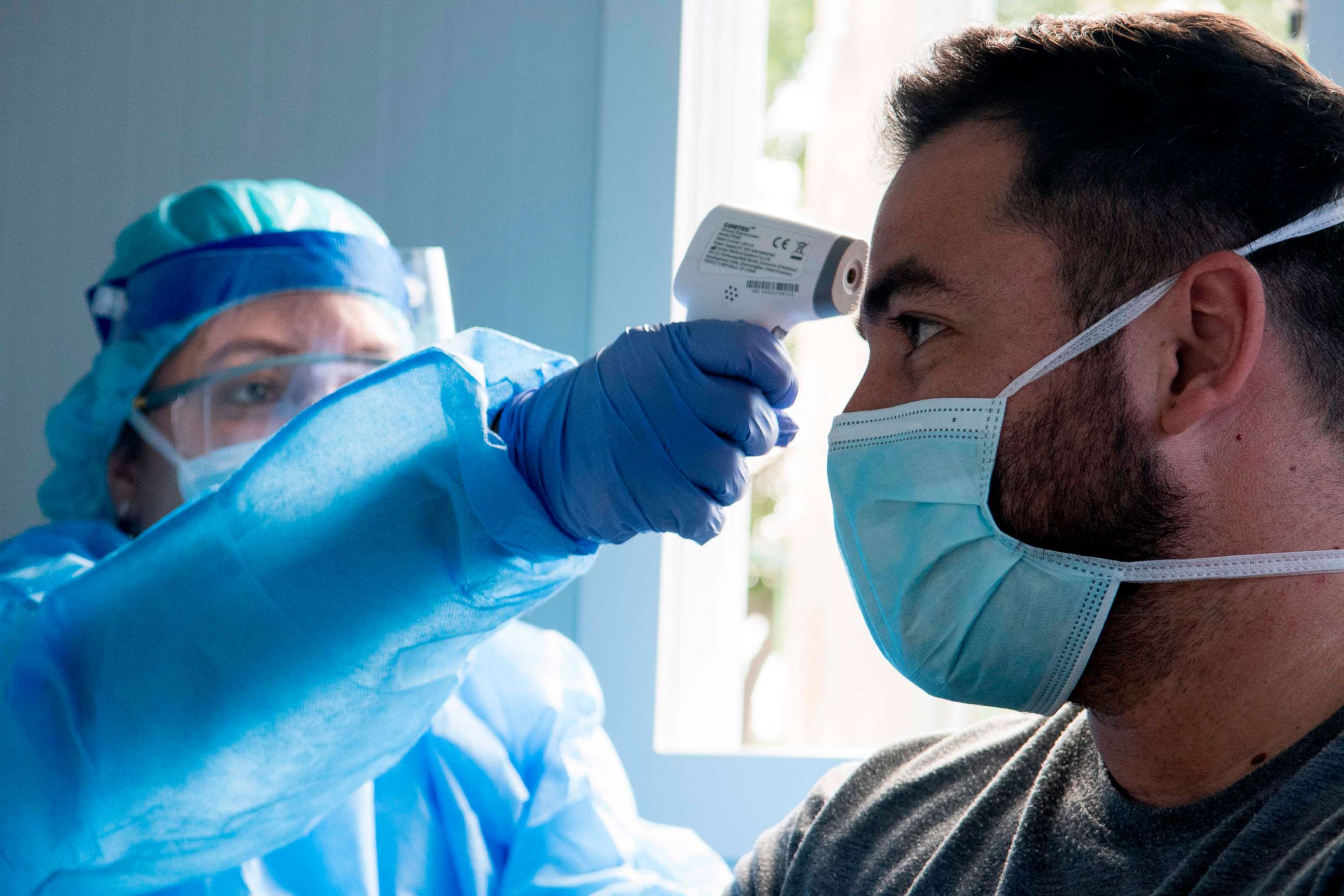 PHOTO: A health worker checks the temperature of a man at a clinic in San Jose, Costa Rica, May 18, 2020, amid COVID-19 pandemic measures. 