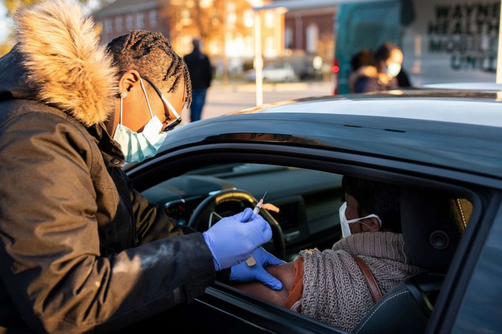 PHOTO: Jakiya West, Wayne Health's certified patient care technician and medical assistant administers a Covid-19 booster shot for April Rogers of Redford outside of Third New Hope Baptist Church in Detroit, Nov. 4, 2021..
