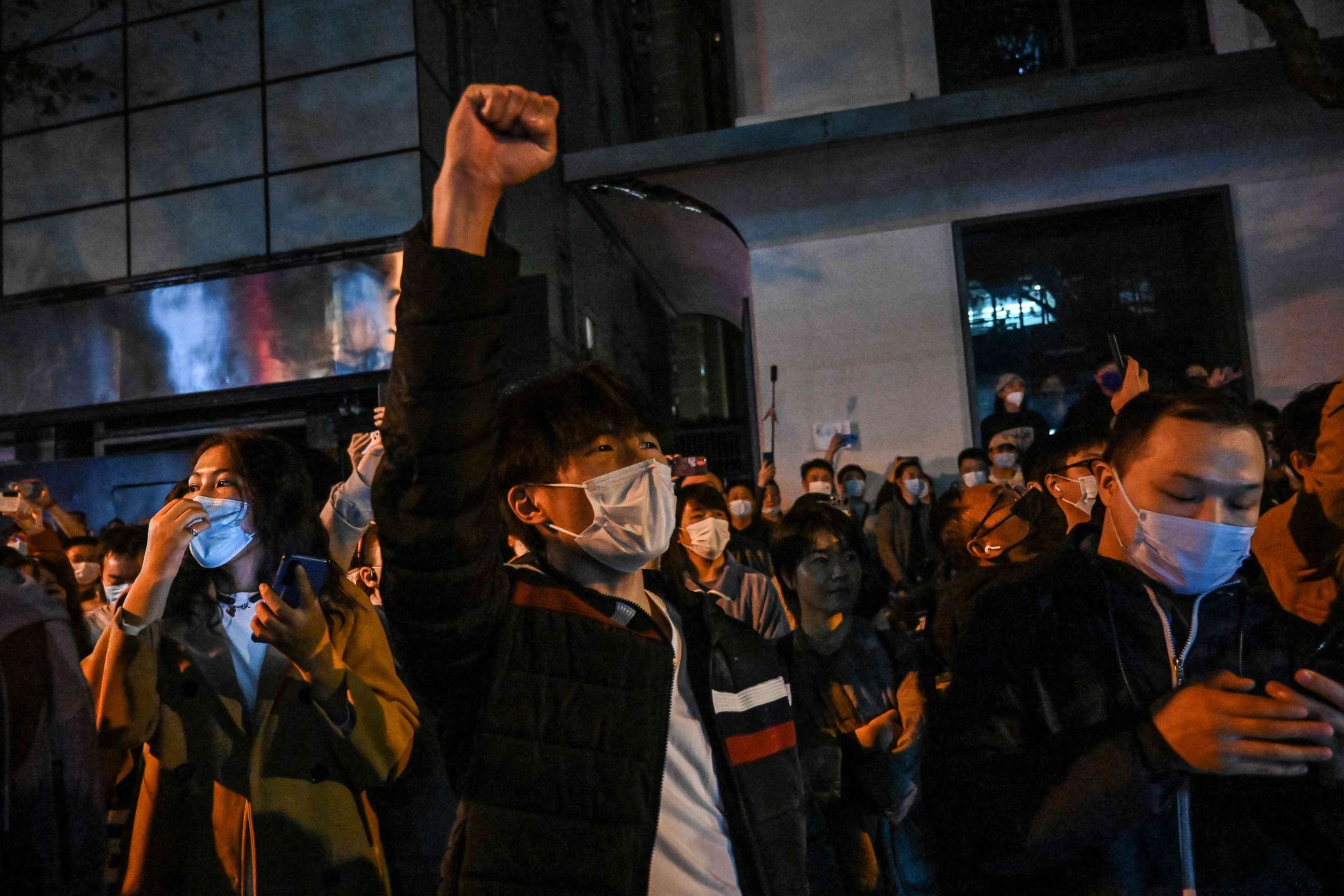 PHOTO: People sing slogans while gathering on a street in Shanghai, Nov. 27, 2022, where protests against China's zero-Covid policy took place the night before following a deadly fire in Urumqi, the capital of the Xinjiang region.