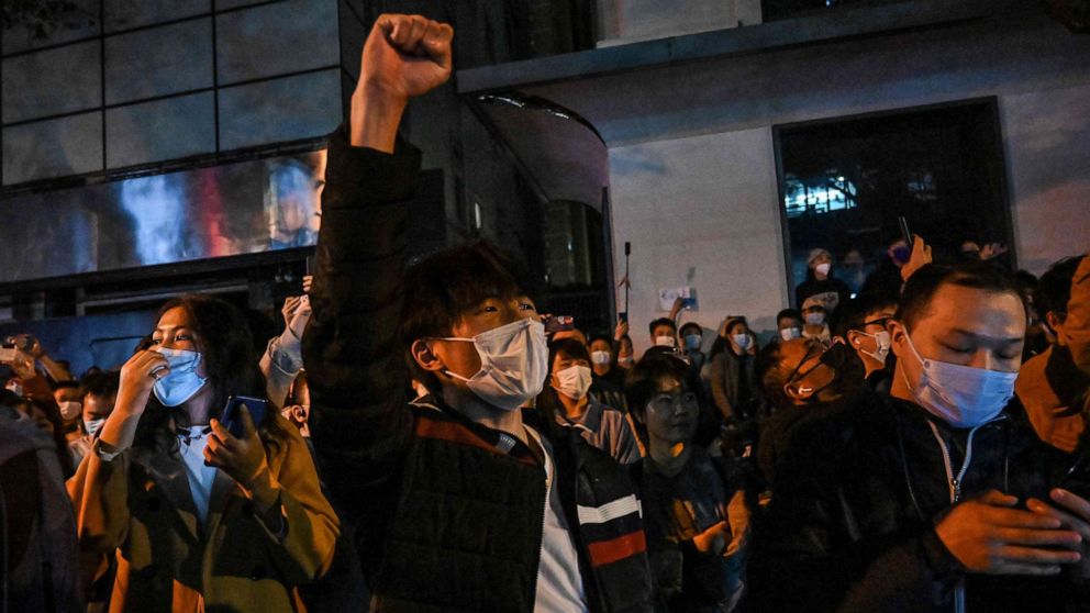 PHOTO: People sing slogans while gathering on a street in Shanghai, Nov. 27, 2022, where protests against China's zero-Covid policy took place the night before following a deadly fire in Urumqi, the capital of the Xinjiang region.