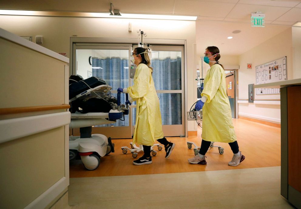 PHOTO: A nurse and a respiratory therapist wheel a COVID-19 positive patient from the emergency room to the ICU at Scripps Memorial Hospital La Jolla in San Diego, Calif., on Jan. 3, 2022.