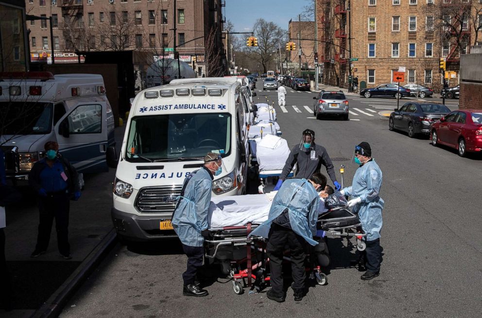 PHOTO: Medics and hospital workers prepare to lift a COVID-19 patient onto a hospital stretcher outside the Montefiore Medical Center Moses Campus on April 07, 2020, in the Bronx borough of New York.