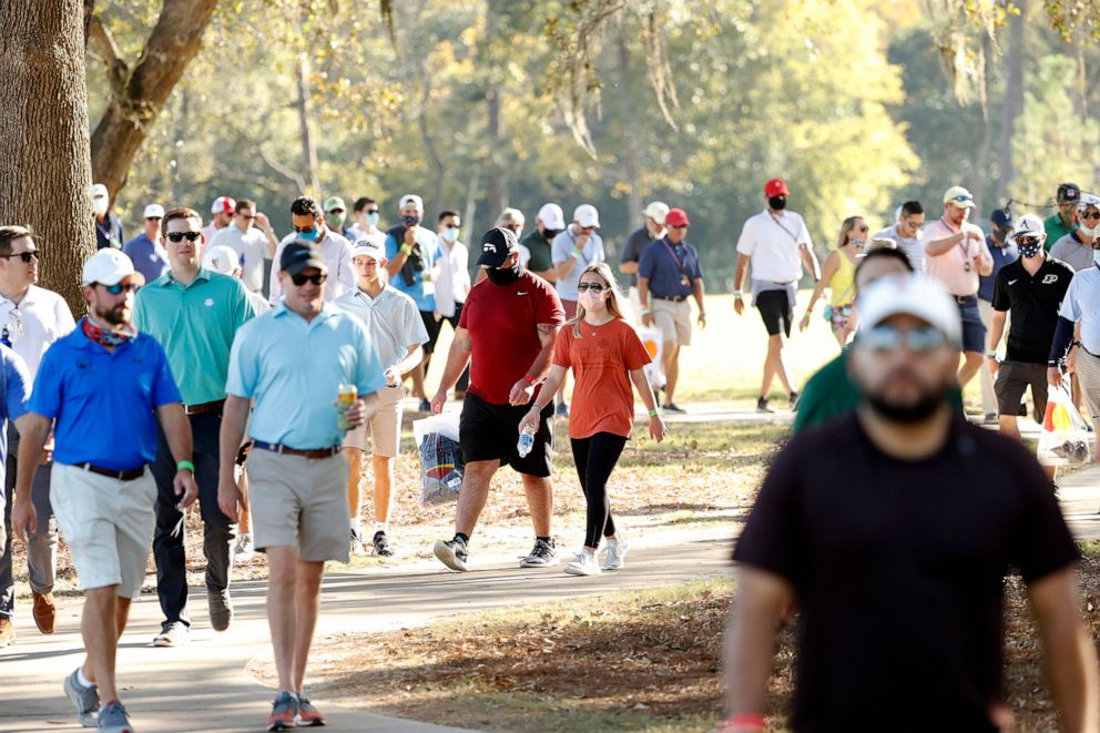 PHOTO: Masked and unmasked fans walk down a path during the second round of the Houston Open at Memorial Park Golf Course in Houston, Texas, Nov. 6, 2020.