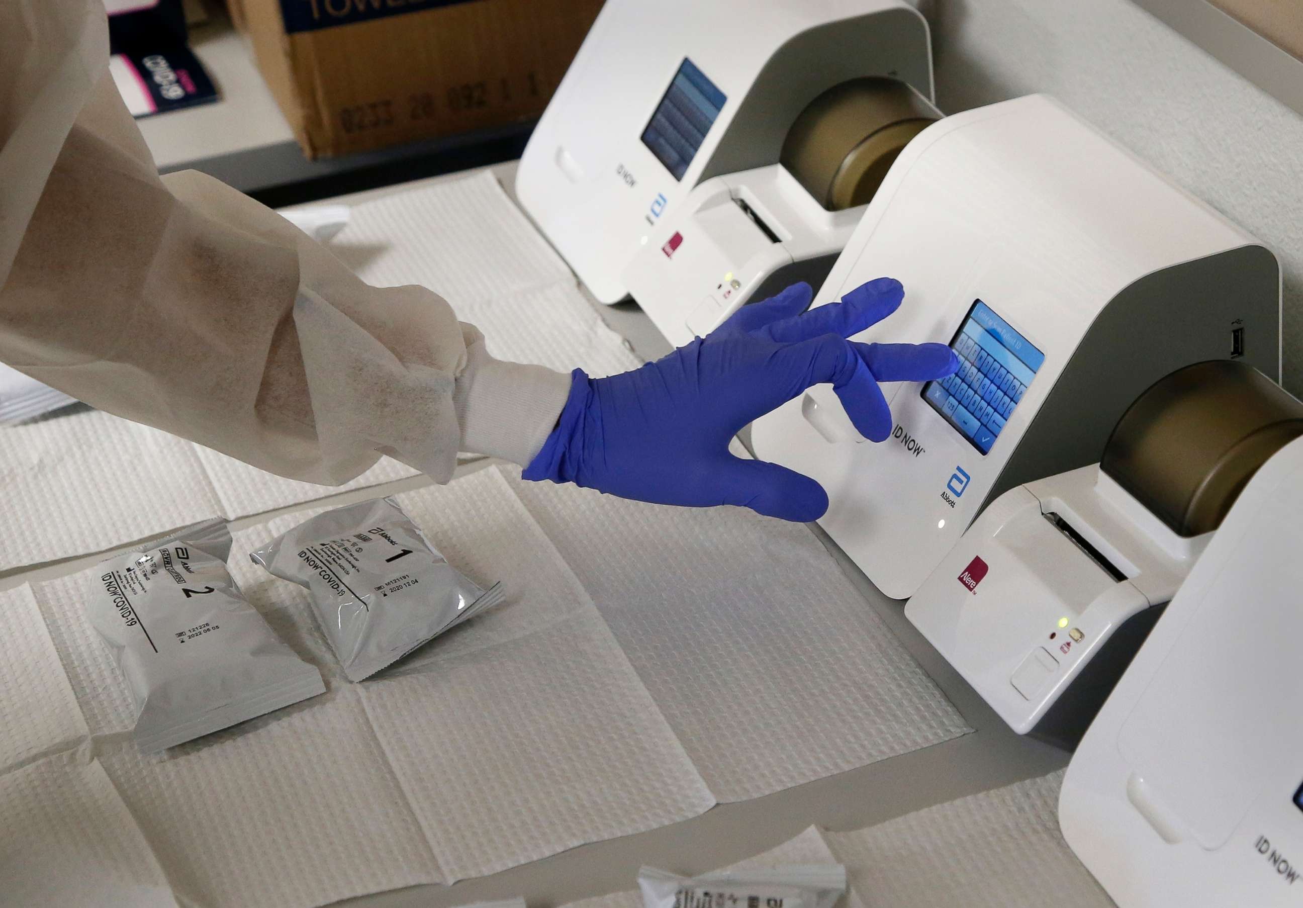 PHOTO: A pharmacy technician demonstrates how COVID-19 tests are processed in a testing area set up by CVS at St. Vincent de Paul medical clinic in Phoenix, June 15, 2020.