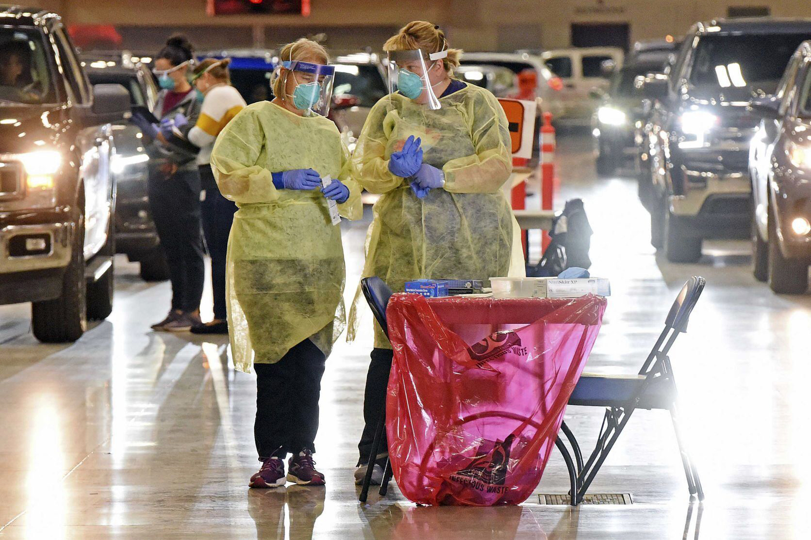 PHOTO: Bismarck-Burleigh Public Health nurses Crys Kuntz, left, and Sara Nelson confer inside the Bismarck Event Center in Bismarck, N.D., where vehicles were lined up for the weekly drive-thru COVID-19 testing, Sept. 8, 2020.